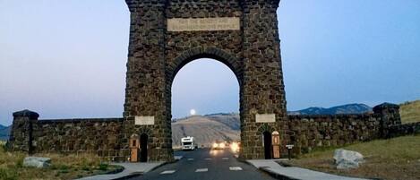 A stone archway with a plaque reading "FOR THE BENEFIT AND ENJOYMENT OF THE PEOPLE" at dusk.
