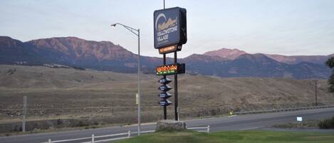 Un cartel con los letreros 'Yellowstone Village' y 'Bienvenido', una señal direccional y una decoración en forma de estrella.