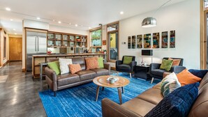 Un salon moderne avec un canapé en cuir marron, une table basse et un tapis bleu.