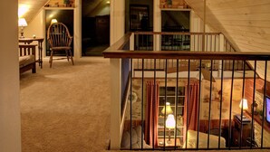 A cozy attic bedroom with a wooden staircase, a comfortable chair, and a small table with a lamp. - Heaven On Earth near The Shenandoah River (Luray)