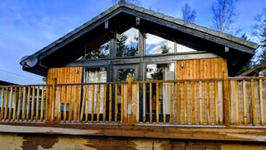 A wooden cabin with a balcony and large windows. - Boutique, 3 bedroom lodge in the heart of Northumberland with private hot tub (Newcastle upon Tyne)