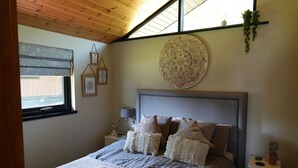 A bedroom with a bed, pillows, a bedside table, a lamp, and a window. - Boutique, 3 bedroom lodge in the heart of Northumberland with private hot tub (Newcastle upon Tyne)