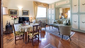 Un comedor con una mesa dispuesta para cuatro, un sofá y un televisor.