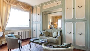 Una habitación con sofá, sillones, una mesa de centro y un radiador.