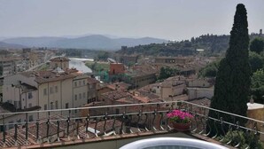 Una azotea con jacuzzi y vistas a un paisaje urbano y un río.