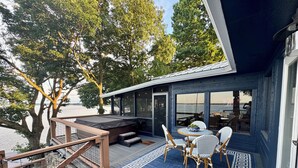 Una terraza con mobiliario exterior, un jacuzzi y vistas al agua.