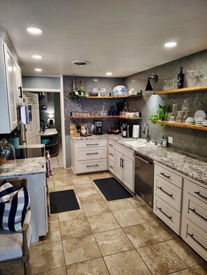 A modern kitchen with white cabinetry, a granite countertop, and a herringbone-patterned backsplash. - "Sunrise Cottage" Beautiful Lakefront Panoramic View W/ Hot Tub and Boat Dock (Vinita)