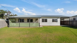 A single-story house with a covered patio, a fenced backyard, and a clear sky. - Len's Retreat - relax in Red Rock (Red Rock)