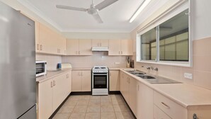 A modern kitchen with a built-in oven, microwave, and stainless steel sink. - Len's Retreat - relax in Red Rock (Red Rock)