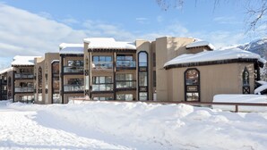 A multi-story hotel with snow-covered roofs and a mountainous backdrop. - SUPER SUMMER GETAWAY  Views + POOL + HOT TUB (WD, FP) (Whistler)
