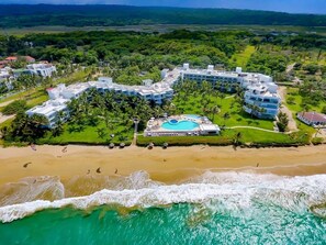A resort with a pool, beachfront, and lush greenery. - 1BR Beachfront Ocean View Apartment in Cabarete (Cabarete)