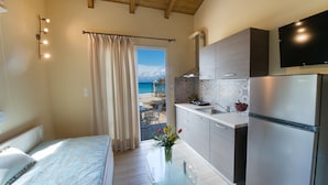 A modern kitchen with a built-in oven, a refrigerator, and a flat-screen TV. - Makis&Fani Homes (Lefkada)