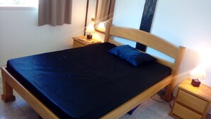 A single bed with a dark blue bedspread and a matching pillow, flanked by two bedside tables with lamps. - HOUSE WITH JACUZZI - SOLARIUM AND PRIVATIVE TENNIS COURT (Praia de Maresias)