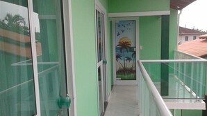 A corridor with glass doors, a mural, and a tiled floor. - House in Balneário Barra do Sul - SC  (Balneário Barra do Sul)