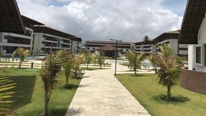 Ein modernes Hotel mit Innenhof, mehreren Gebäuden und einem Schwimmbad.