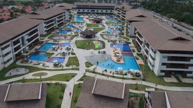 Ein Resort mit mehreren Schwimmbecken, einem zentralen Innenhof und umliegenden Gebäuden.