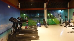Ein Fitnessraum mit Laufbändern, einem Ergometer und einem Rudergerät.