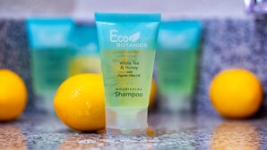 Een fles Eco Botanics Nourishing Shampoo met witte thee & honing en biologische olijfolie.