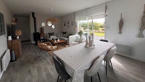 A spacious living area with a dining table, seating, and a view of the outdoors. - A haven of peace with Spa at 2 steps from the beach (Cléder)