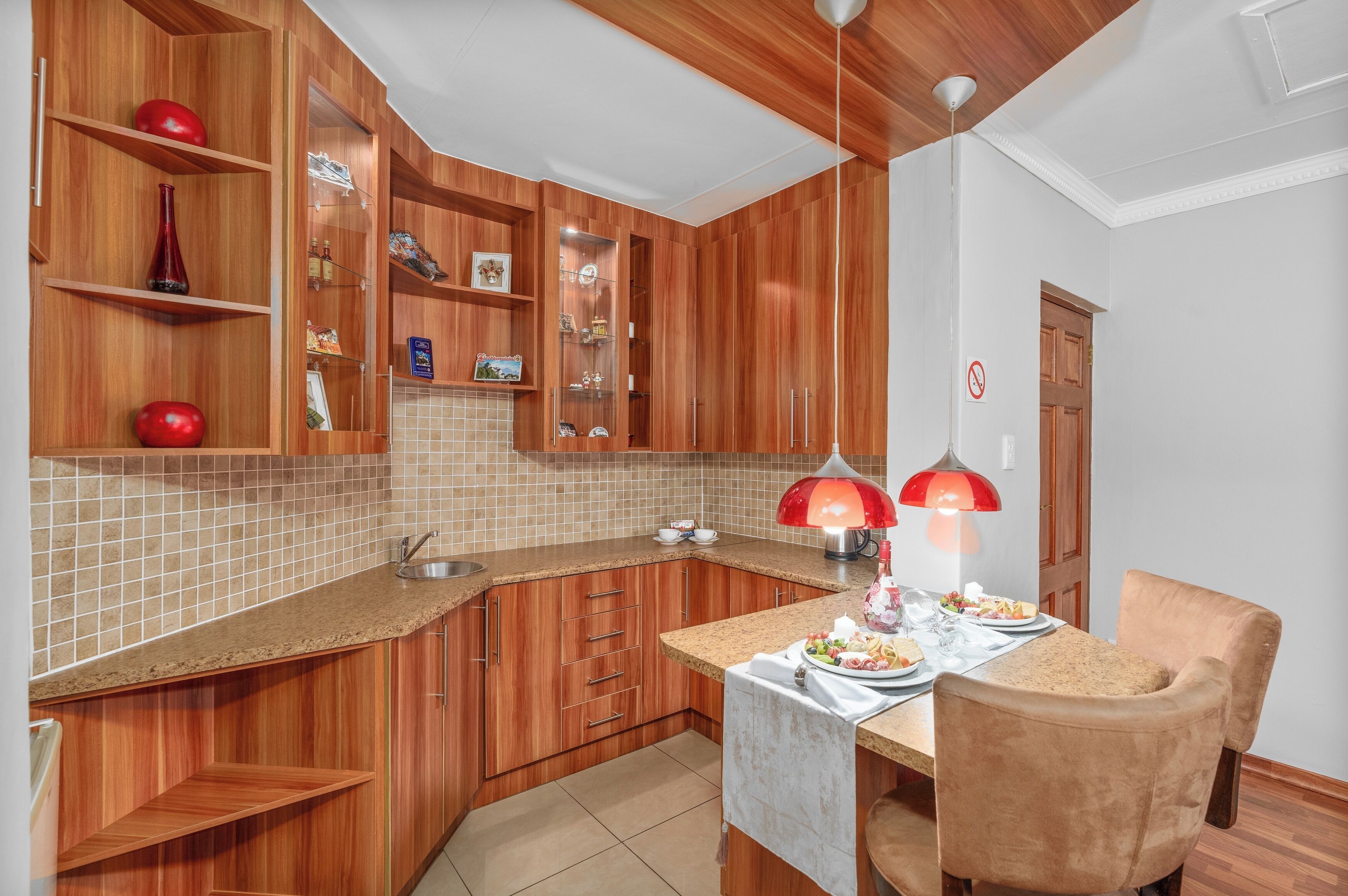 Een moderne keuken met houten kastjes, een granieten aanrecht en een eethoek met een tafel en stoelen.