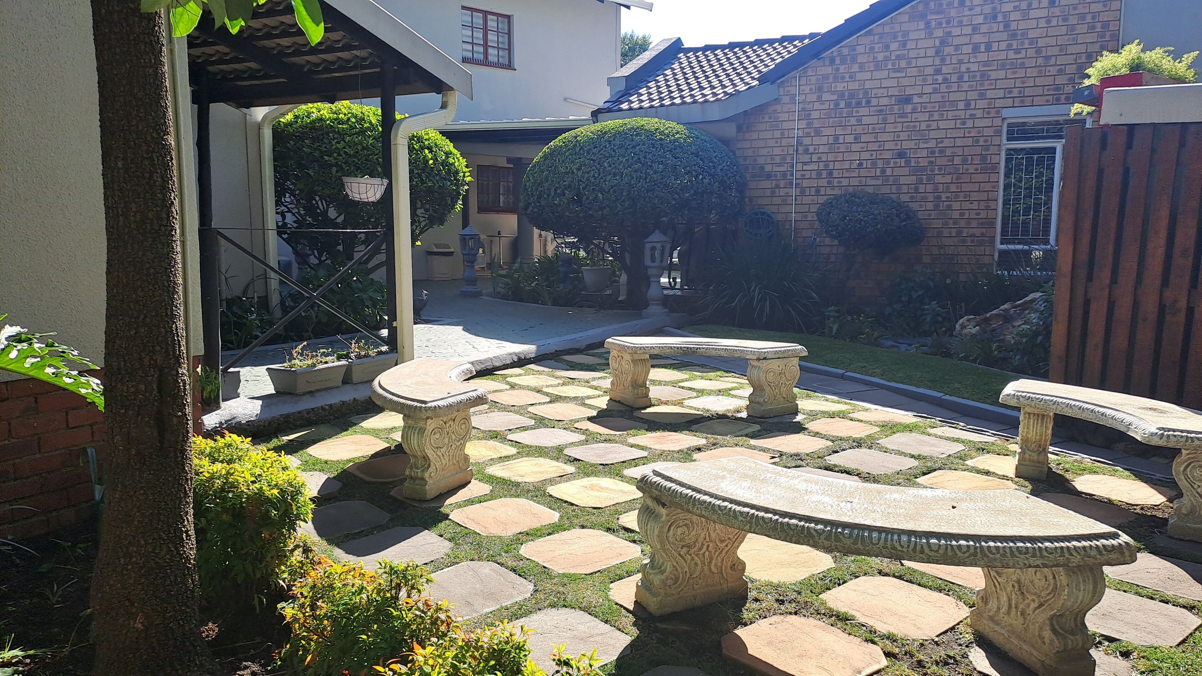 A courtyard with stone benches and a patterned stone pathway.