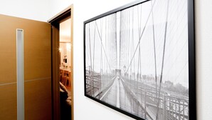 A framed photograph of a bridge on a wall, a wooden door, and a glimpse of a dining area. - JL Guest House Daikokucho (Osaka)