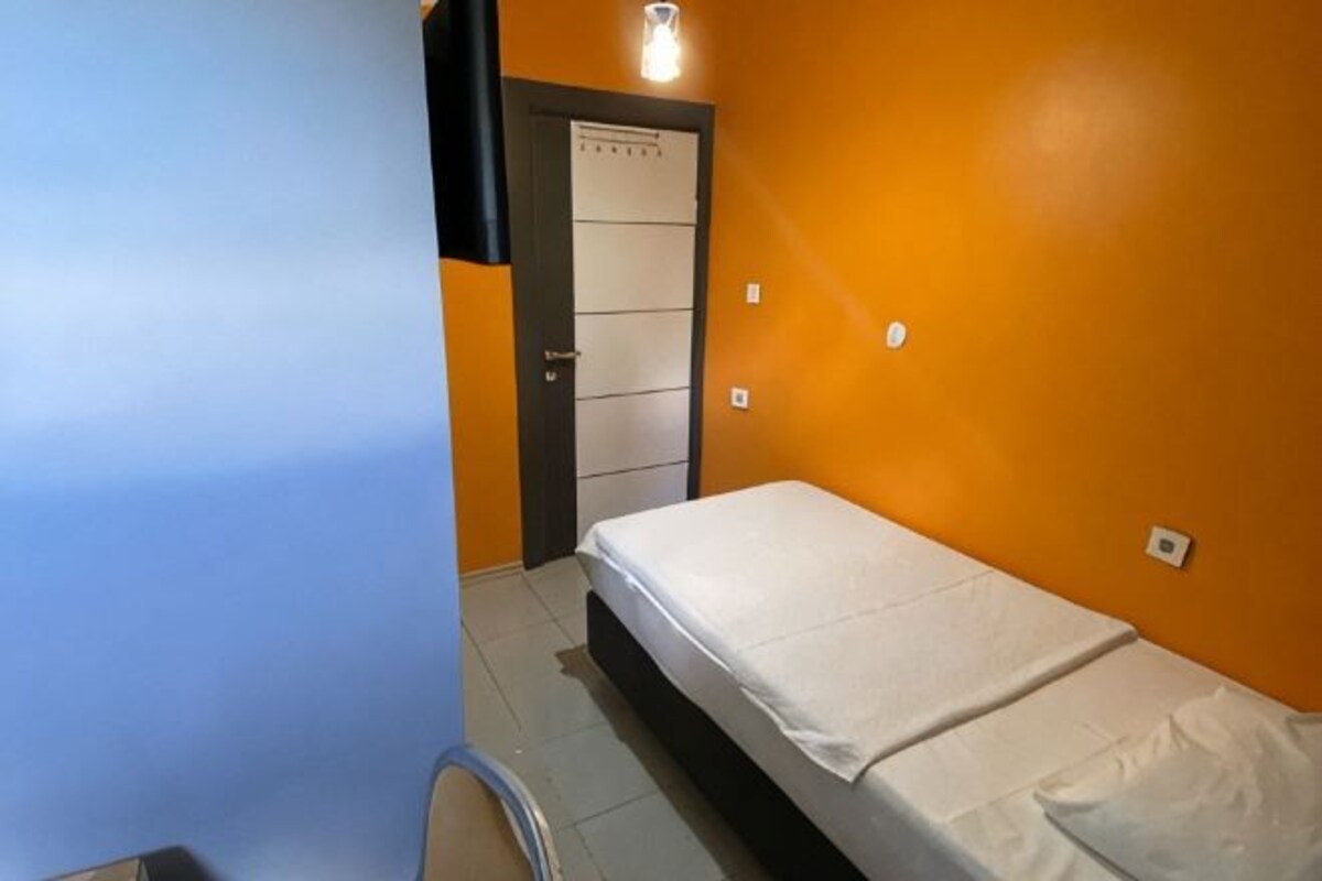 Une pièce avec un lit, une porte et un luminaire.