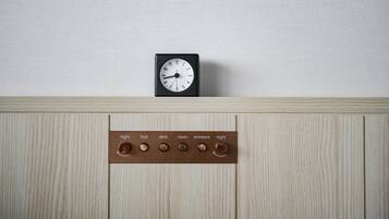 A wall-mounted clock and a control panel with buttons labeled "night," "foot," "desk," "room," "entrance," and "night."