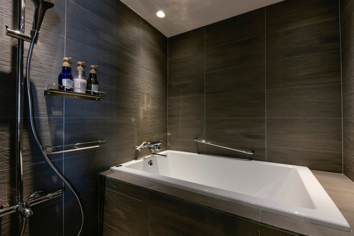 deluxe room, non smoking | bathroom | combined shower/bathtub, free toiletries, hair dryer, slippers