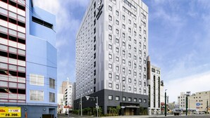 Een modern hotelgebouw met een opvallende ingang en een bord dat aangeeft dat het een hotel is.