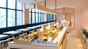 Een moderne cafeteria met lange tafels, een buffetgedeelte met diverse gerechten en grote ramen voor natuurlijk licht.