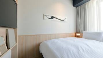 Habitación de hotel con cama, televisor de pantalla plana montado en la pared, una obra de arte en la pared y ventana con cortinas.