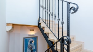 Un escalier avec des rampes en métal noir et des marches en bois.