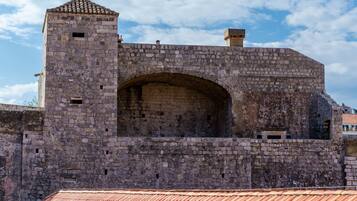 A stone fortress with a large arched entrance and a small tower.