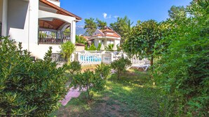 A white building with a balcony, a pool, and a garden area with trees and shrubs. - Brooklandparis Villa by Nokta Villa (Fethiye)