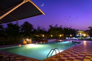 Una piscina al aire libre, sombrillas