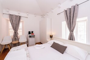 A hotel room with a bed, two chairs, a desk, and a lamp. - Cinema View House (Dubrovnik)