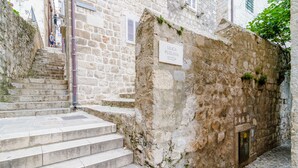 Una escalera de piedra que lleva a un edificio con un cartel que dice "ULICA PUZLIJA".