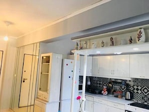 Compact kitchen with refrigerator, microwave, and ample storage.