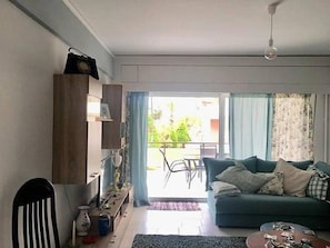 Relax in this stylish living room with a sofa, chair, and balcony view.