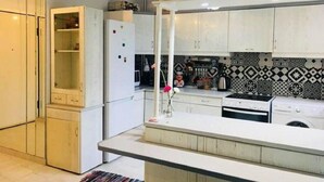 Uma cozinha moderna com armários brancos, forno embutido e painel decorativo.