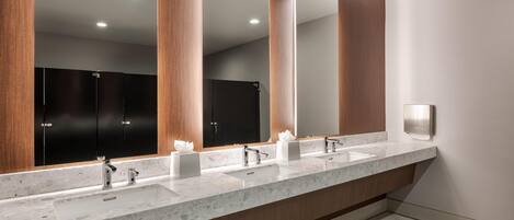Un baño moderno con un tocador amplio, dos lavamanos y un espejo grande.
