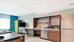 A modern kitchen with a microwave, refrigerator, and wooden cabinets. - Home2 Suites by Hilton Alameda Oakland Airport (Alameda)