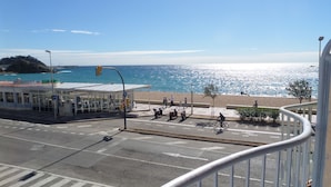 Une rue côtière avec un passage piéton, un feu de signalisation et une vue sur la mer.