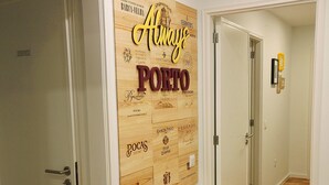 Un couloir doté d’un plancher en bois et d’une enseigne fixée au mur, sur laquelle figurent différentes marques de vin portugais.