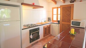 A kitchen with a refrigerator, stove, oven, microwave, and sink. - Idyllic casita in Soller with garden and pool (Sóller)