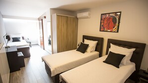 Een hotelkamer met twee bedden, een bureau en een stoel.