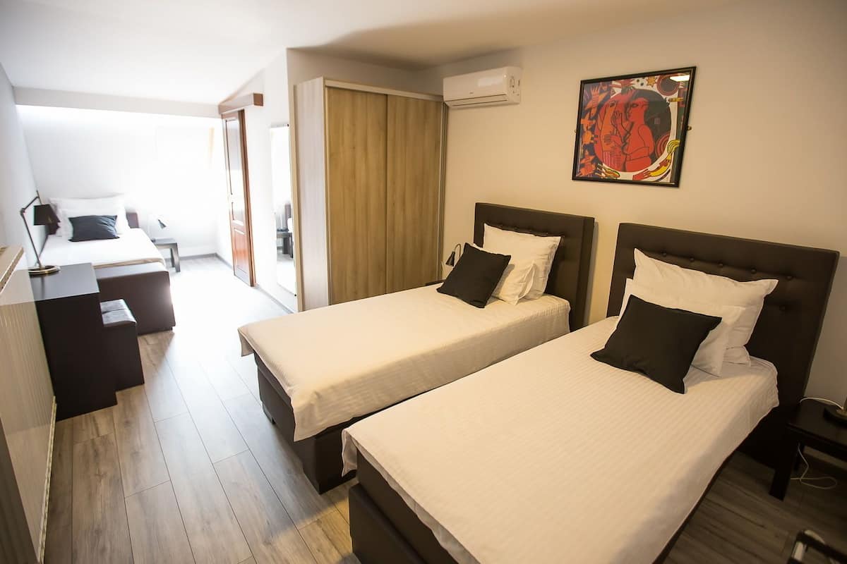 Une chambre d’hôtel avec deux lits, un bureau et une chaise.