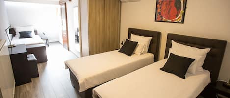 Habitación de hotel con dos camas, un escritorio y una silla.