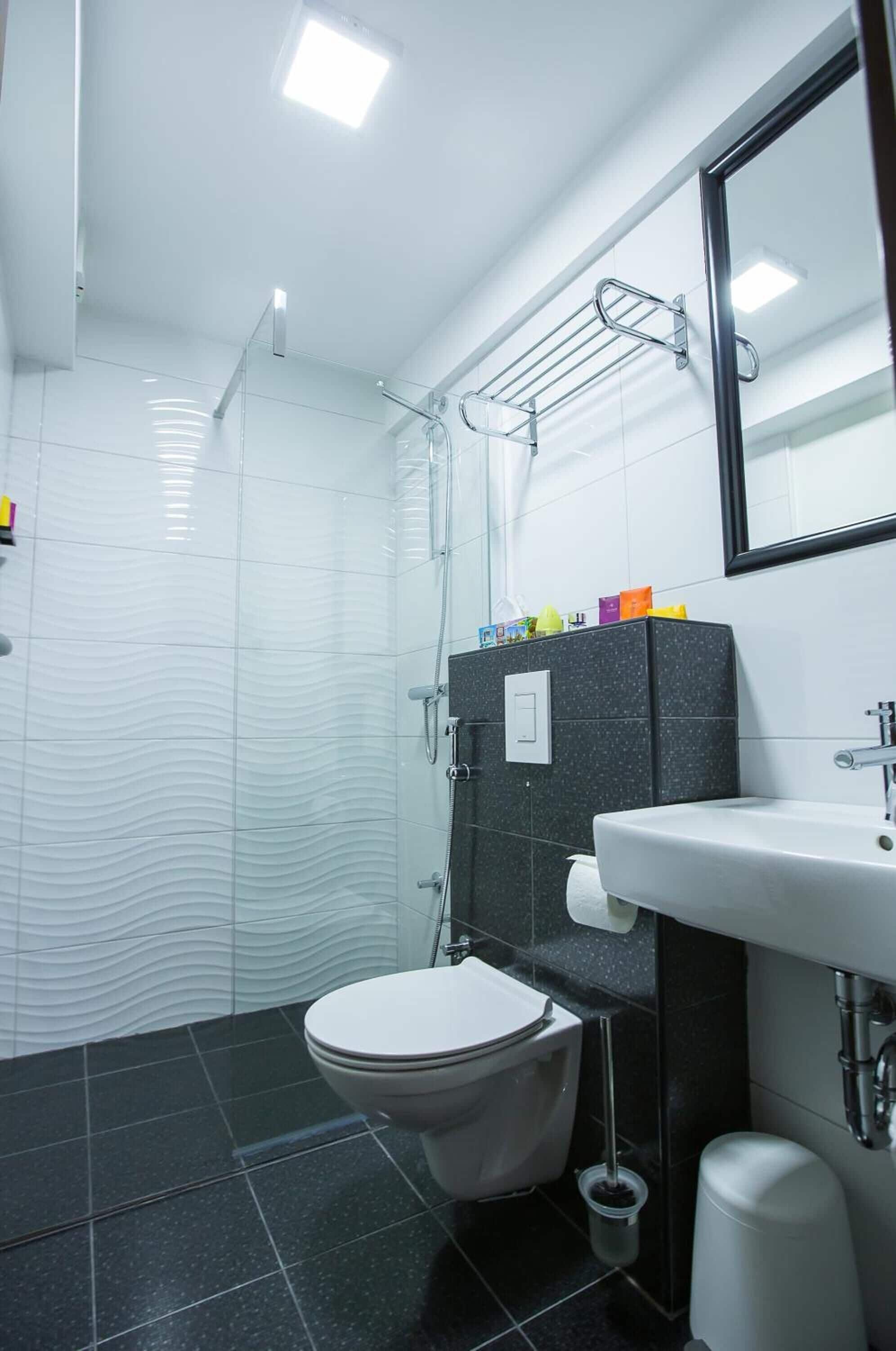 Une salle de bain moderne équipée de toilettes, d’un lavabo et d’une douche.